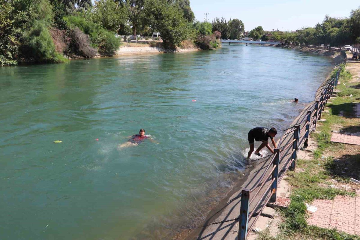 Kavurucu sıcakta hem kanalda yüzdüler hem karpuz yediler
